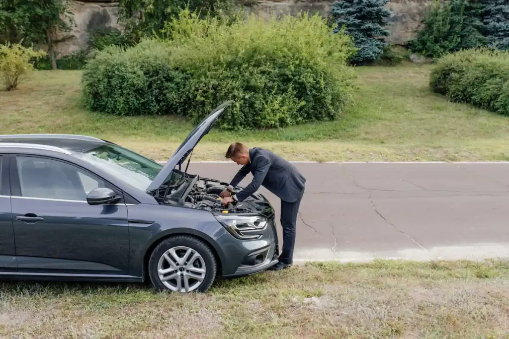 Une personne qui regarde sous le capot d'un clio 4