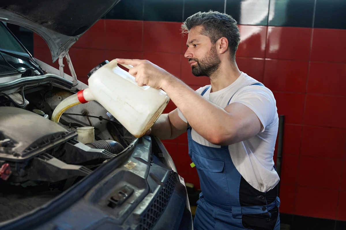 Un homme qui change l'huile de direction assistée de voiture