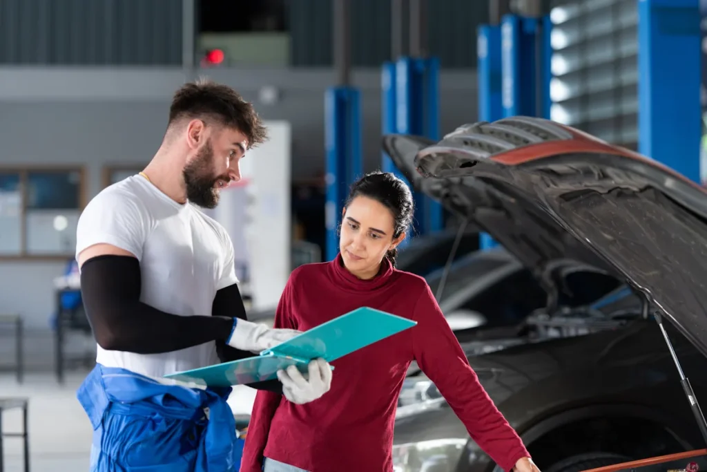 Une femme qui fait vérifie sa voiture par un garagiste avant le contrôle technique
