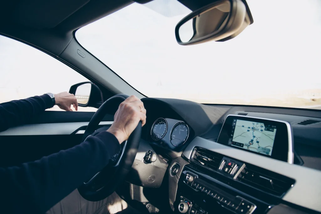 Un homme qui conduit une voiture avec une direction assistée qui siffle