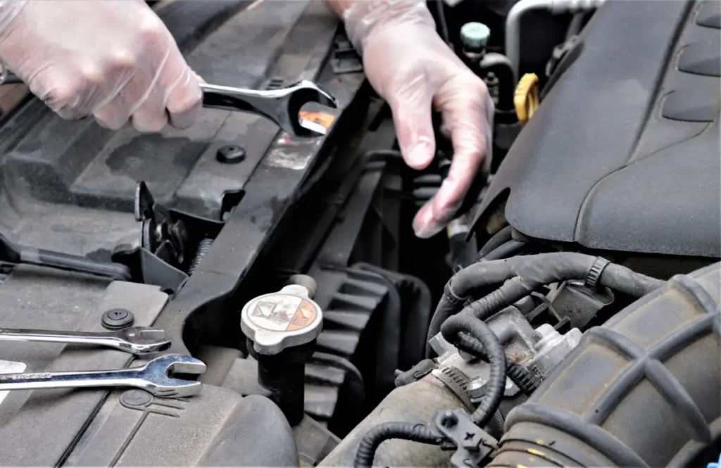 Une personne qui change le courroie d'une clio
